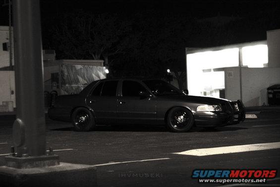 Dark Ford Crown Victoria with a push bar parked at night