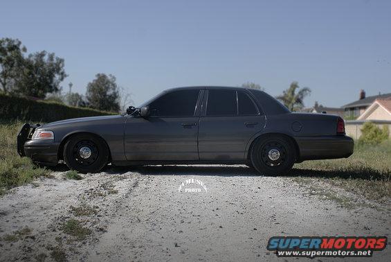 Dark gray 2005 Ford Crown Victoria, side view, with push bumper and tinted windows