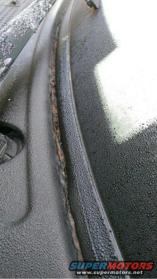 Windshield cowl with water droplets and rust. A Supermotors.net logo is visible