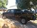 1993 Ford F-350 - This black crew cab pickup truck has a utility bed and chrome wheels, seen from a 3/4 front angle.