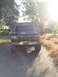 1993 Ford F-350 - A dark Ford F-Series truck is parked on a paved surface, with trees and a building visible in the background.