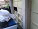 1988 Ford Bronco - A white tarp covers a blue vehicle part, partially obscuring the interior of a garage.