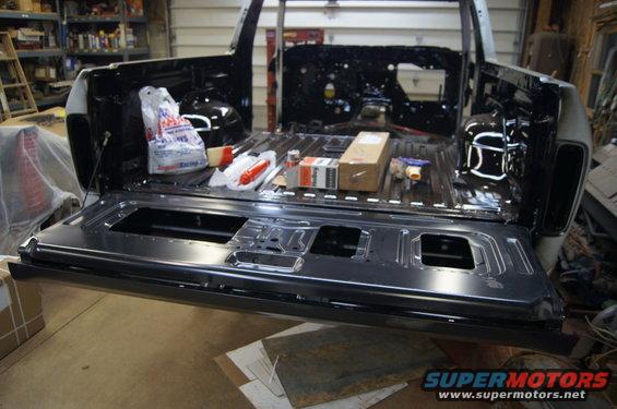 1979 Ford Bronco tailgate and bed in black, open, with parts and bags inside