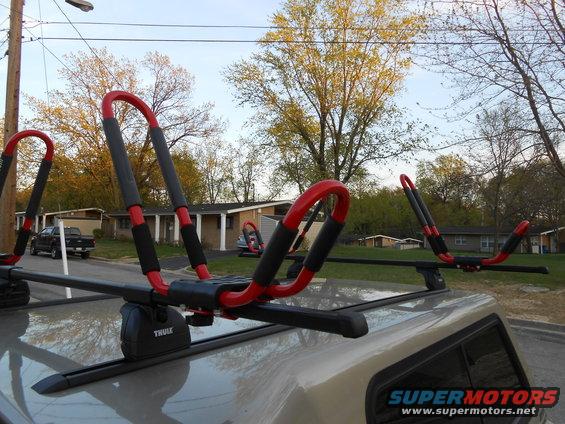 Kayak rack on car roof with a black pickup truck in the background