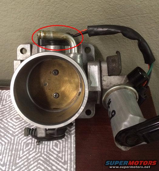 Ford throttle body assembly with a metal vacuum line circled in red