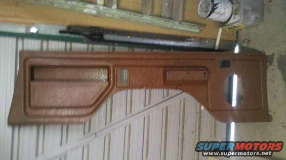 Brown door panel with speaker cutout and storage pocket