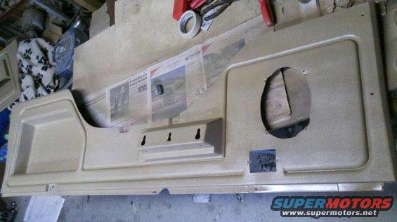 Tan interior door panel with speaker cutout and storage pocket