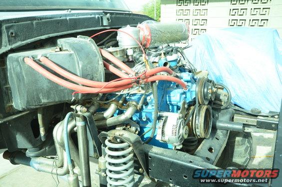 Engine bay with blue engine block, red hoses, and aftermarket air filter