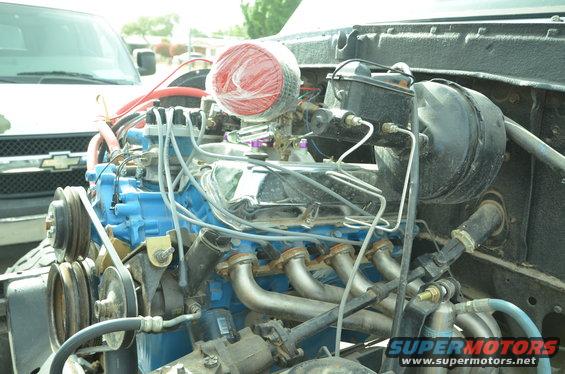 Engine bay with blue engine block, chrome valve covers, and red air filter