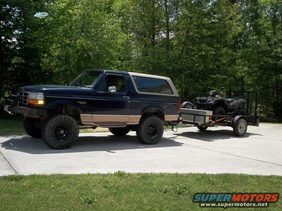 Dark blue SUV towing a trailer with an ATV