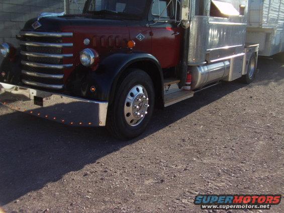 Diamond T truck with red and black cab, chrome grille, and silver trailer