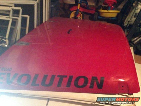 Red car hood with black text that says "ROAD EVOLUTION"