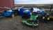 2011 Yamaha GRIZZLY 660 - A collection of lawn tractors and farm equipment are gathered outdoors near a large red container.