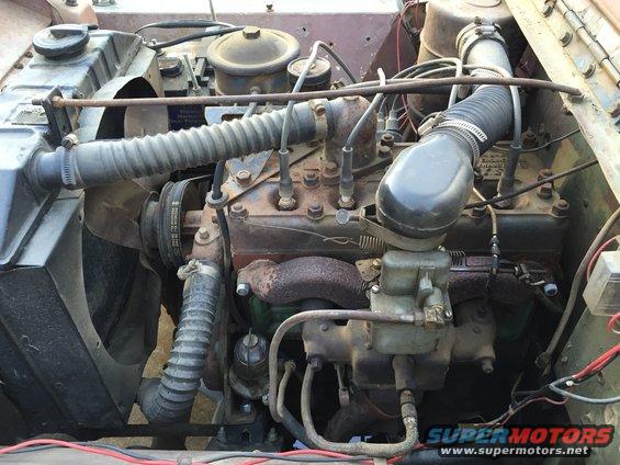 Engine bay with a rusty inline-four engine, radiator, and hoses