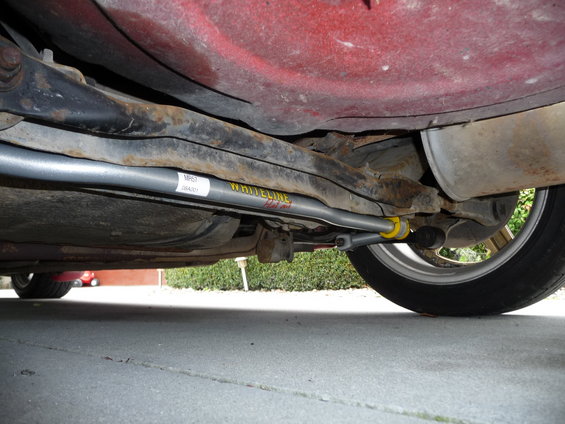 Underside of a car showing the rear suspension and a gray sway bar with yellow bushings and 'WHITELINE' text