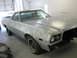 1973 Ford Ranchero - This coupe utility vehicle, appearing to be a 1972 Ford Ranchero, is in primer and undergoing repairs in a garage.