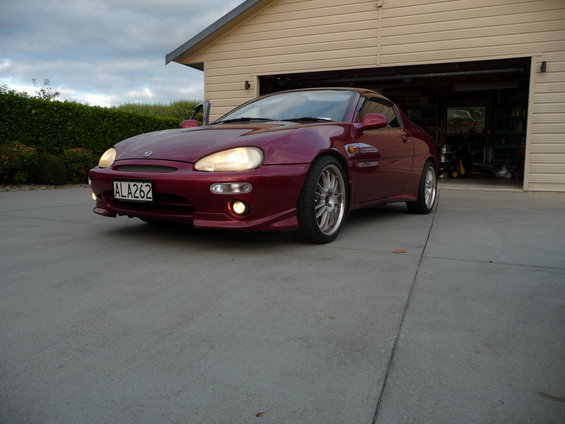 1993 Mazda MX-3, red, parked in driveway with garage in background