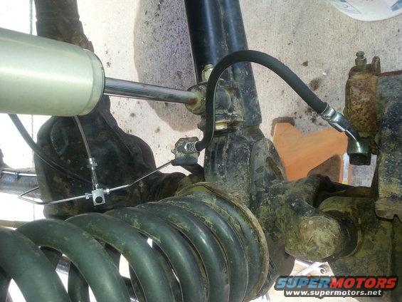 Close-up of a shock absorber attached to a coil spring and suspension components