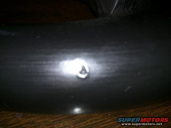Close-up of a dark tire with a small dent or imperfection