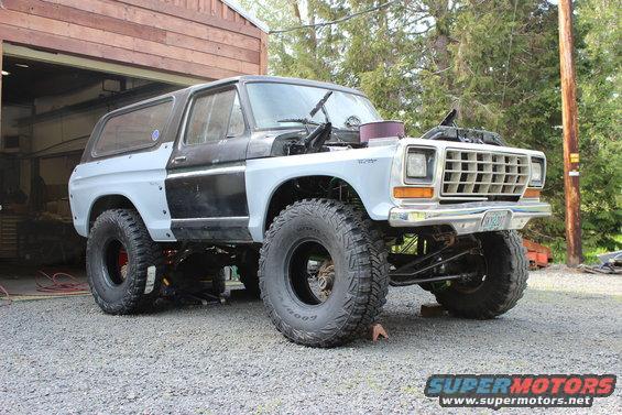 Light blue and black 1979 Ford Bronco with large tires and aftermarket fenders