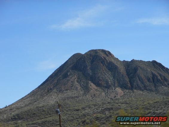 Mountain landscape under a clear blue sky with a utility pole in the foreground