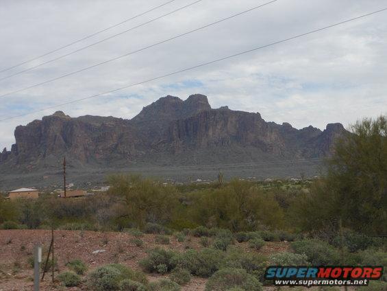 Desert landscape with mountains and vegetation, Supermotors logo