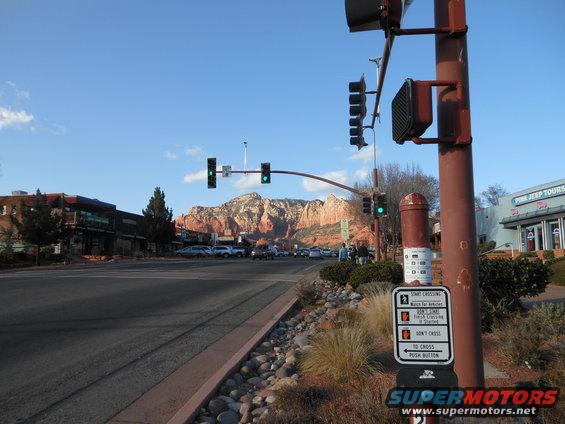 Street scene in Sedona, Arizona with red rock mountains in the background and traffic lights