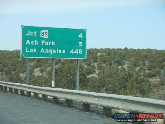 Green highway sign indicating Jct 89, Ash Fork, and Los Angeles