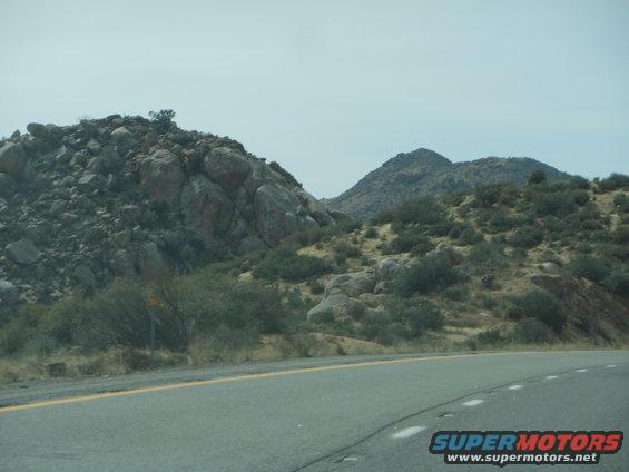 Desert landscape with rocky hills and a road in the foreground