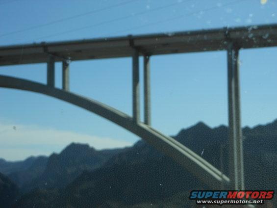 Bridge structure against a clear blue sky with mountains in the background