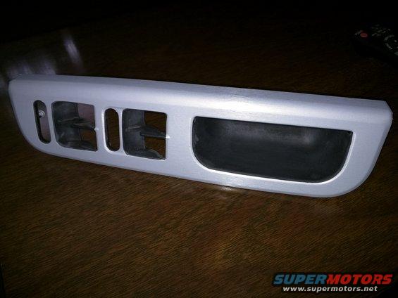 Silver interior trim piece with three rectangular air vents and a large black insert