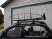 1964 Volkswagen Beetle - Side view of a black 1964 Volkswagen Beetle fitted with a roof rack and an auxiliary headlight.