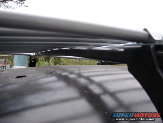 Close-up of a roof rack mounted on a dark-colored vehicle roof