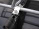 1964 Volkswagen Beetle - Close-up view of metal brackets and bolts securing a roof rack to a vehicle's surface.