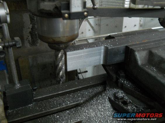 Milling machine cutting a metal part, metal shavings visible