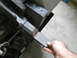 1992 Ford Bronco - A metal piece is being cut with a band saw in a workshop setting.