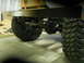 1992 Ford Bronco - Close-up view of the rear axle and chunky tires on a vehicle, with a metal bumper overhead.