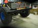 1992 Ford Bronco - Rear view of a modified truck chassis with a large fuel tank and off-road tires.