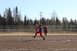 1990 Chevrolet Suburban - A softball pitcher throws a pitch during a game on a sunny day.