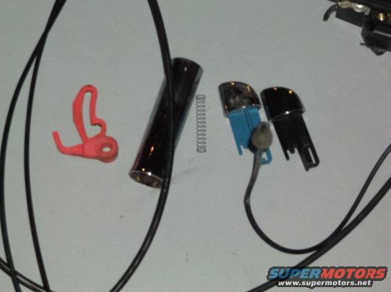 Car door lock cylinder, spring, and two plastic key fobs with a red plastic clip
