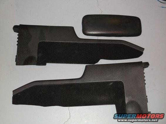 Two black plastic trim pieces with carpeted inserts and a black armrest pad