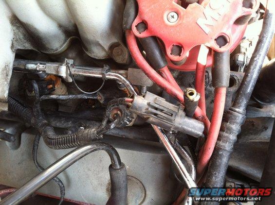 Engine bay showing fuel injectors and red spark plug wires