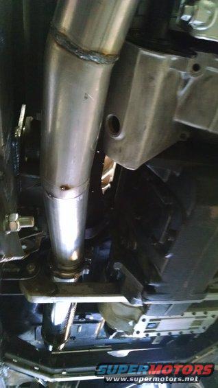 Underside view of a vehicle's exhaust pipe and frame components