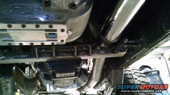 Underside view of a vehicle's transfer case, labeled 'ATLAS 2-Sp', with exhaust pipes and suspension components visible