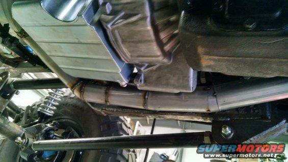 Underside of a vehicle showing exhaust pipes, suspension, and transmission housing