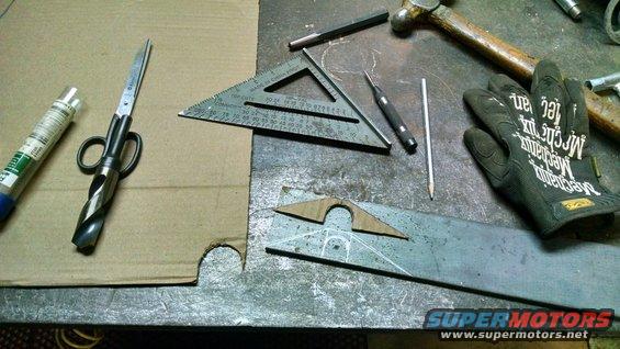 Workbench with drill bit scissors, square, scribe, pencil, hammer, and metal pieces