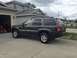 2004 Jeep Grand Cherokee - A dark gray 2004 Jeep Grand Cherokee is parked in a driveway on a cloudy day.