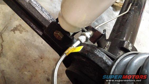 Brake fluid reservoir and lines attached to metal frame