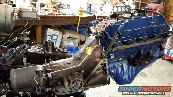 Blue engine and transmission assembly suspended by chains