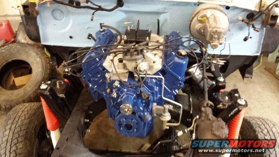 1978 Ford Bronco engine bay with blue engine and red shock absorbers